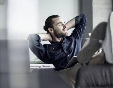 man relaxing with his arms behind his head image