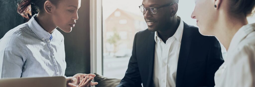 office workers around a table full width image
